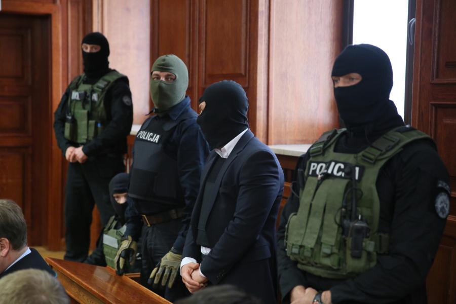 Kelner Łukasz N., chroniony przez uzbrojonych antyterrorystów i w kamizelce kuloodpornej, zasiada na ławie oskarżonych w Sądzie Okręgowym w Warszawie
